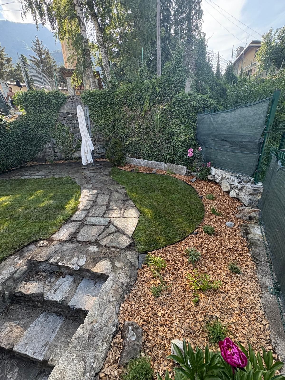 Prato curvo con bordura in corteccia, vialetto in pietra e rose, lavoro realizzato da Lisa Garden